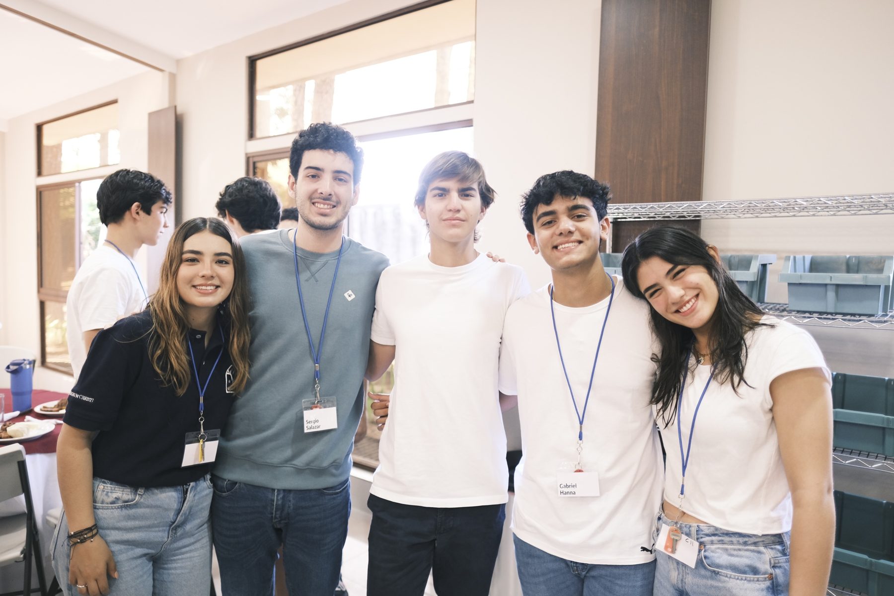 Cinco jóvenes sonriendo juntos